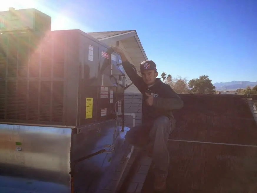 HVAC technician performing Boiler Repair on a rooftop unit in Ponca City